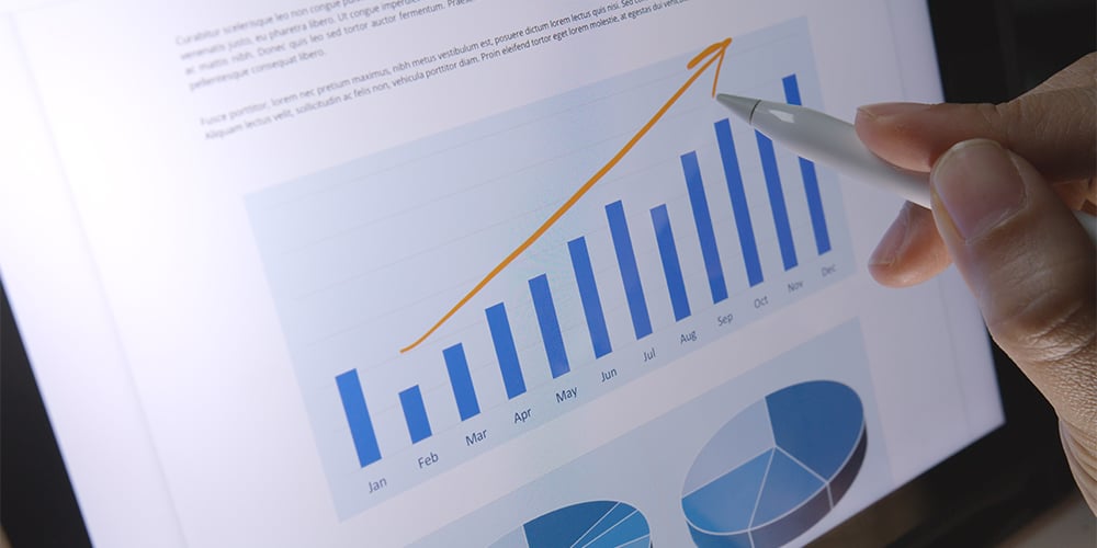 Person drawing an arrow over growth chart on iPad